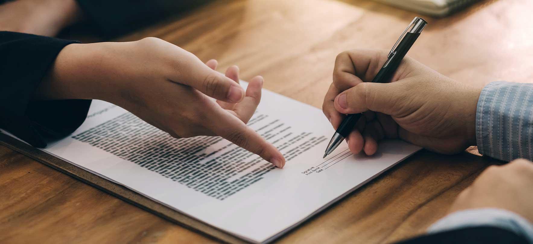 un documento siendo firmado por una persona. 