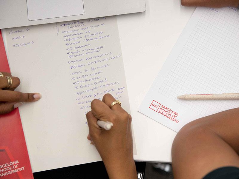 persona redactando un documento sobre un escritorio