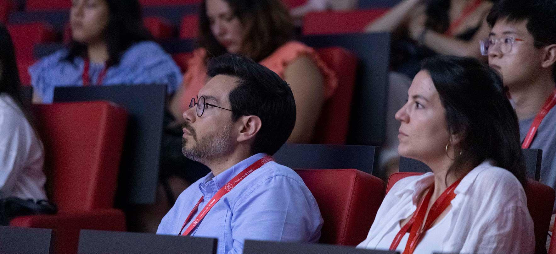 Audience attending a business conference, focused and engaged with the presentation