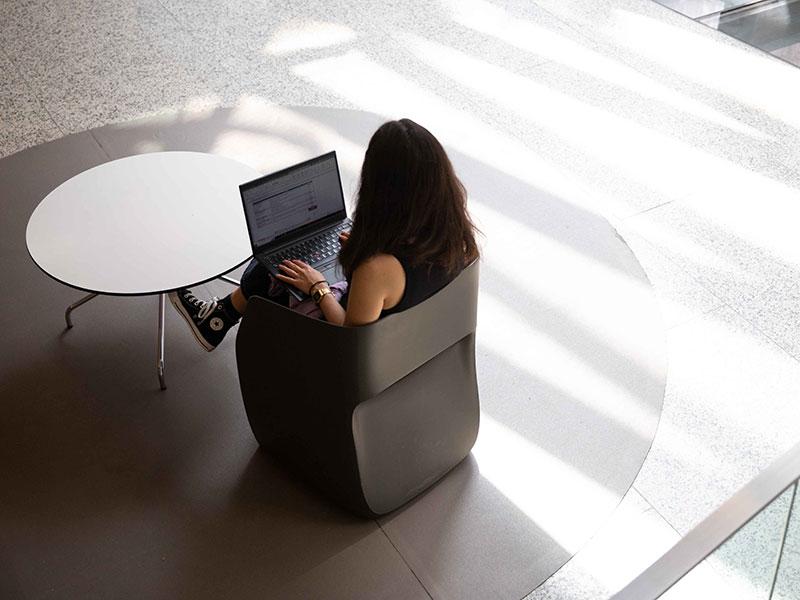 alumna con ordenador en un espacio diafano