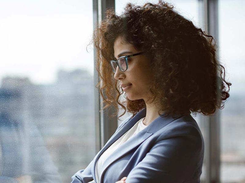 Abogada mirando por la ventana de la oficina