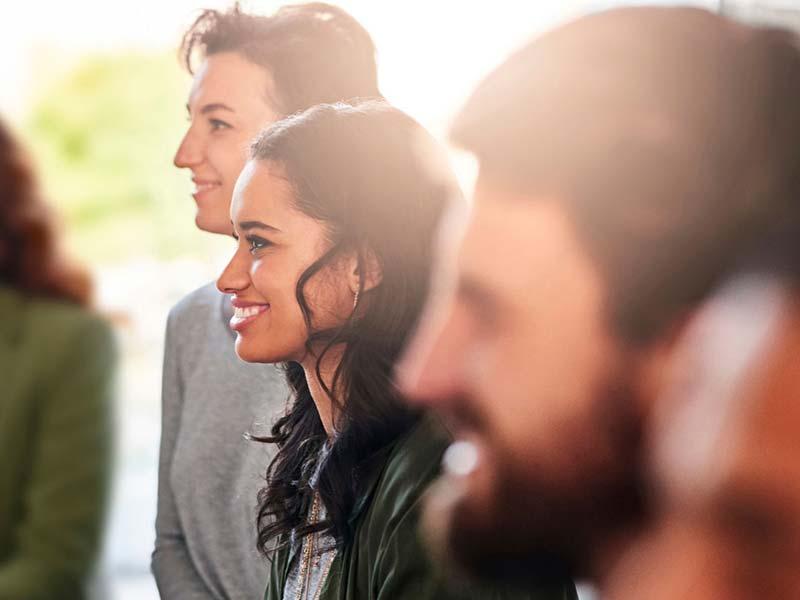 Group of young professionals attentively listening in a bright indoor setting